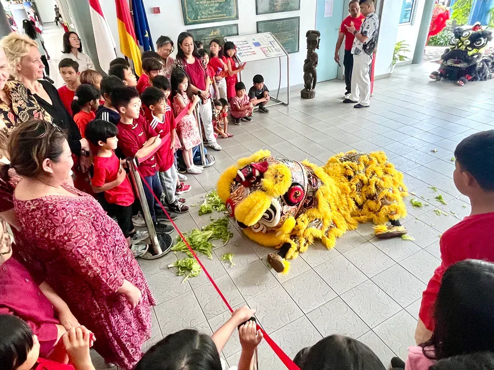 A group of children are watching a lion dance.