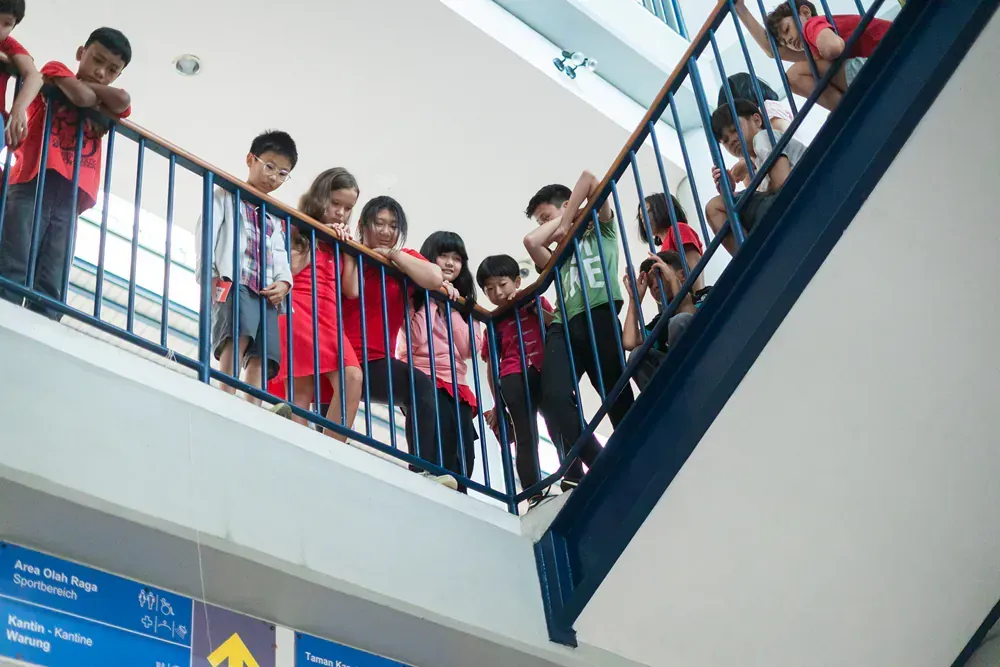 A group of children are standing on a set of stairs.