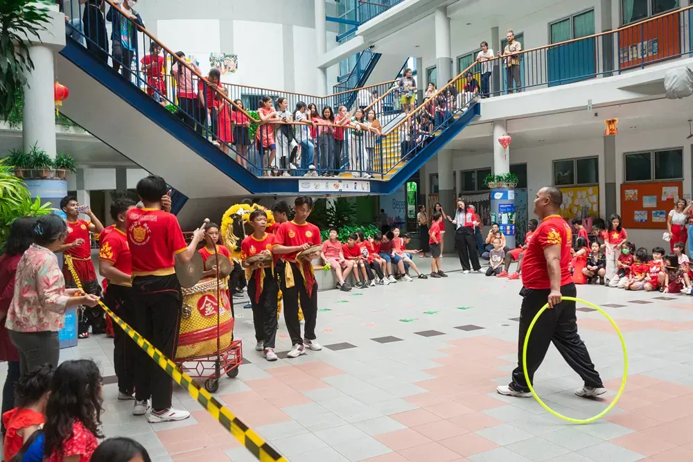 A man is walking with a hula hoop in front of a crowd of people.