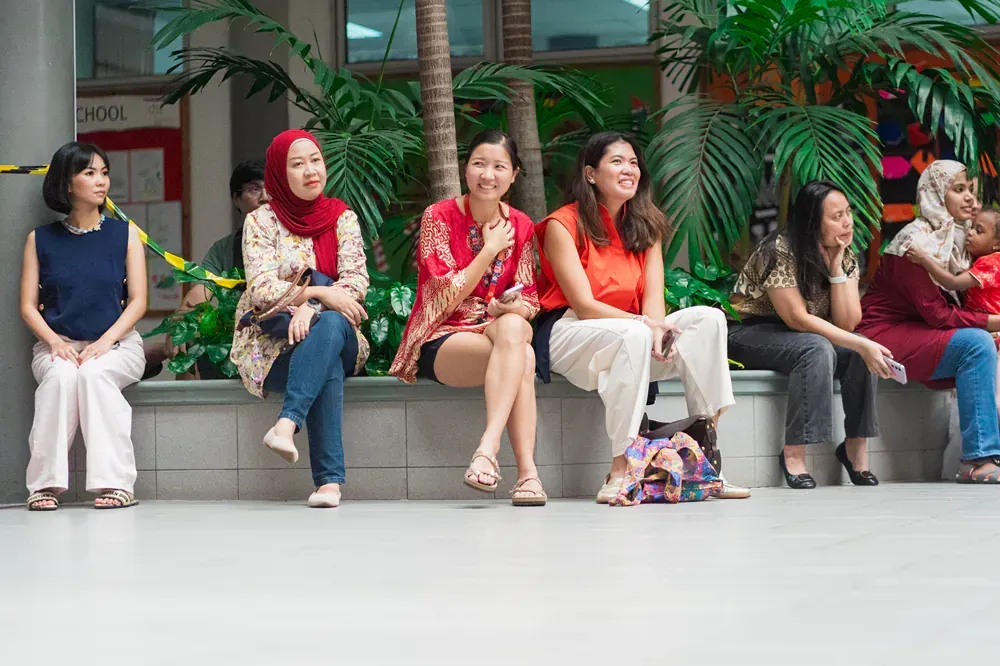 A group of women are sitting on a wall.