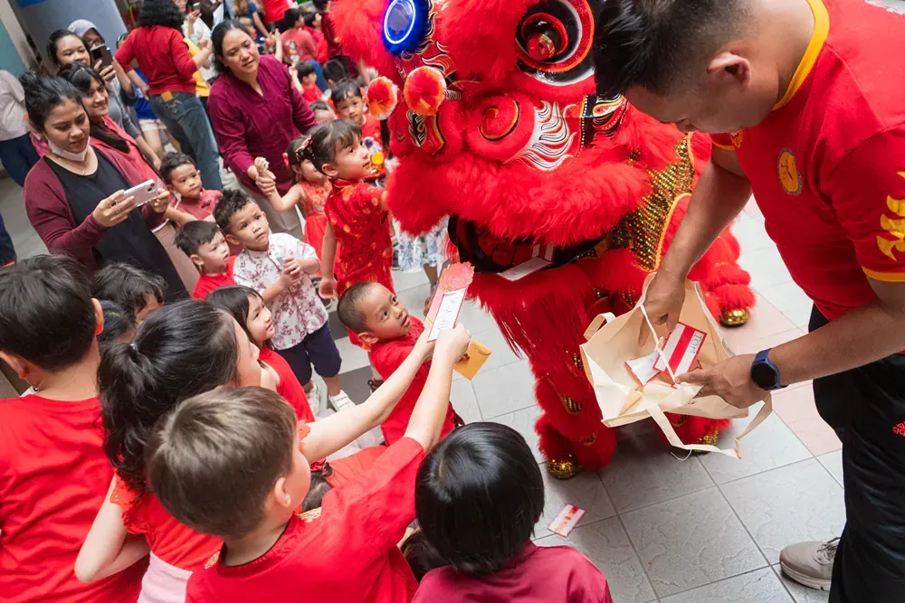 A group of children are playing with a lion costume.