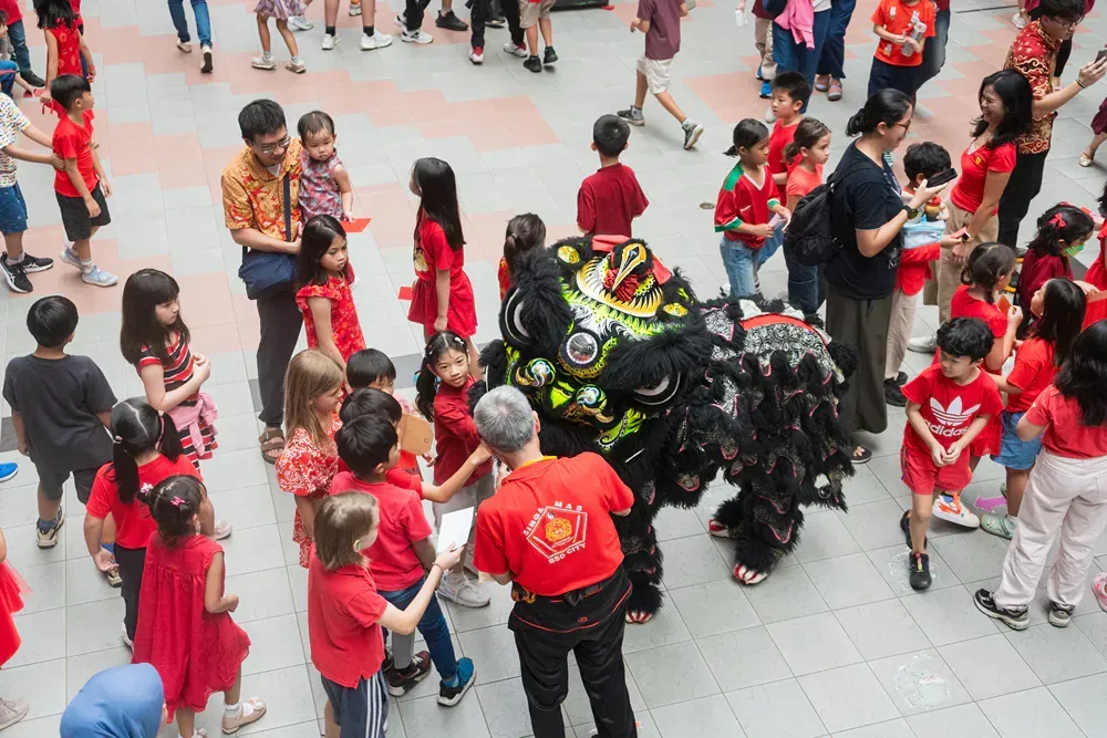 A group of people are standing around a lion.