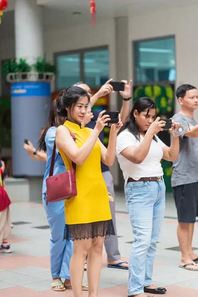 A group of people are taking pictures with their cell phones.