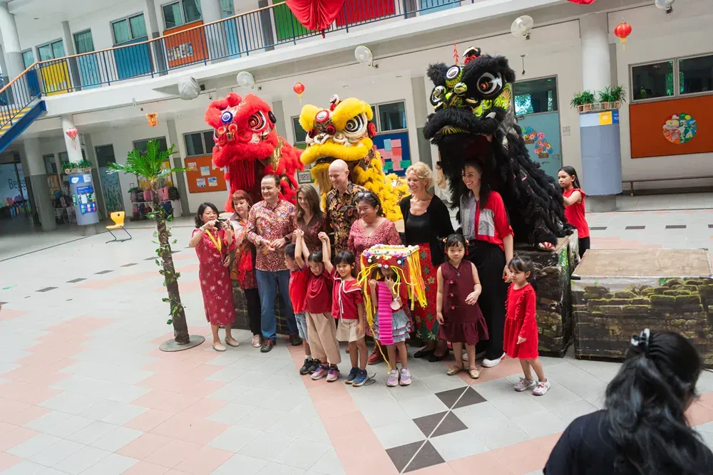 A group of people are posing for a picture in front of a lion costume.