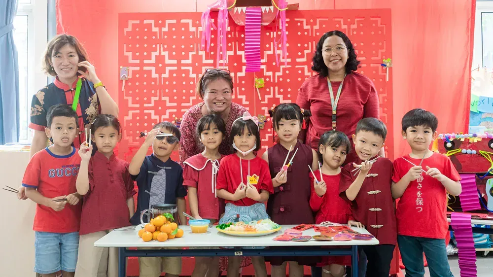 A group of children are posing for a picture in front of a table.