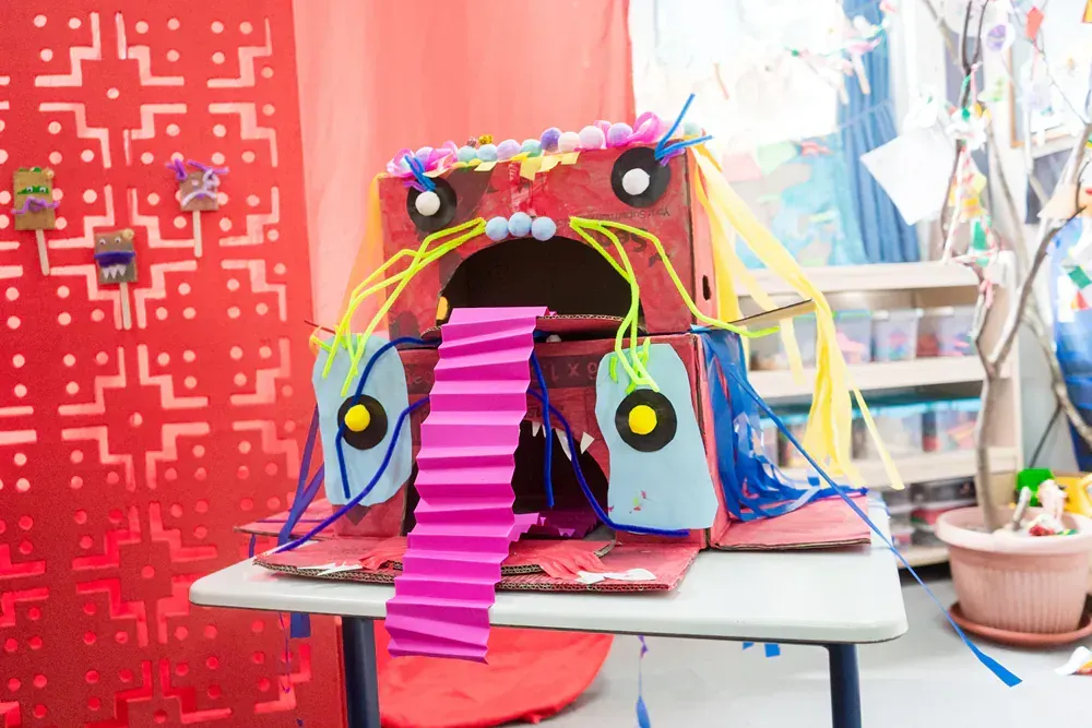 A sculpture made out of cardboard and paper is sitting on a table.