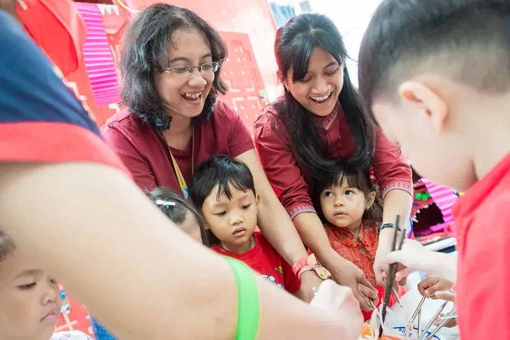 A group of people are standing around a table with children.