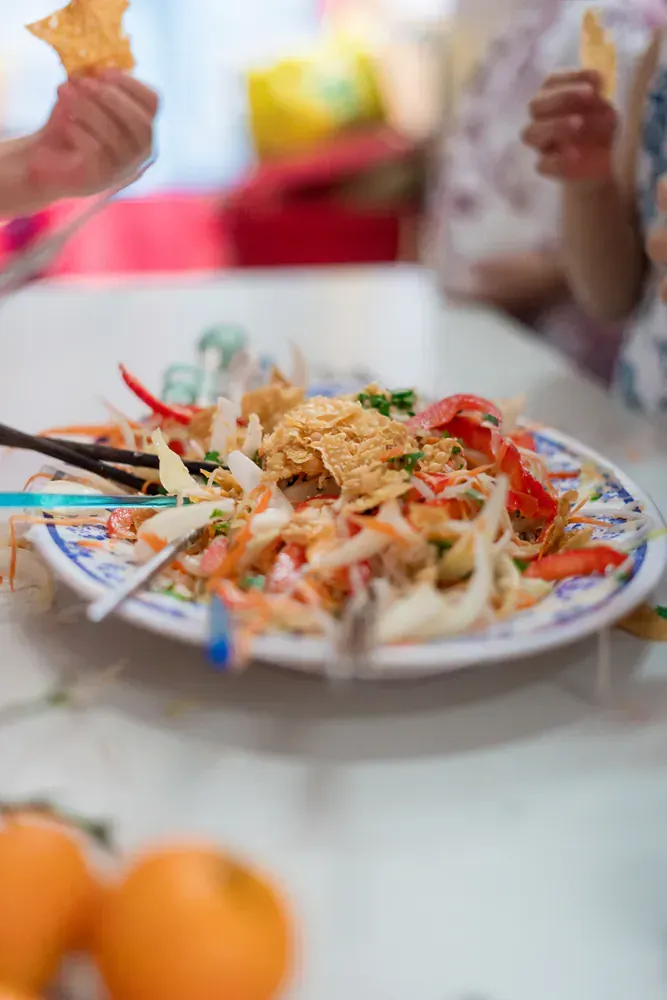 A close up of a plate of food with chopsticks on a table.