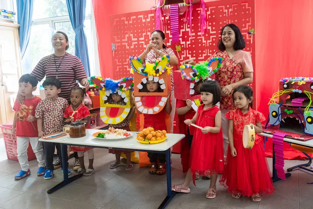 A group of children are standing around a table in a room.