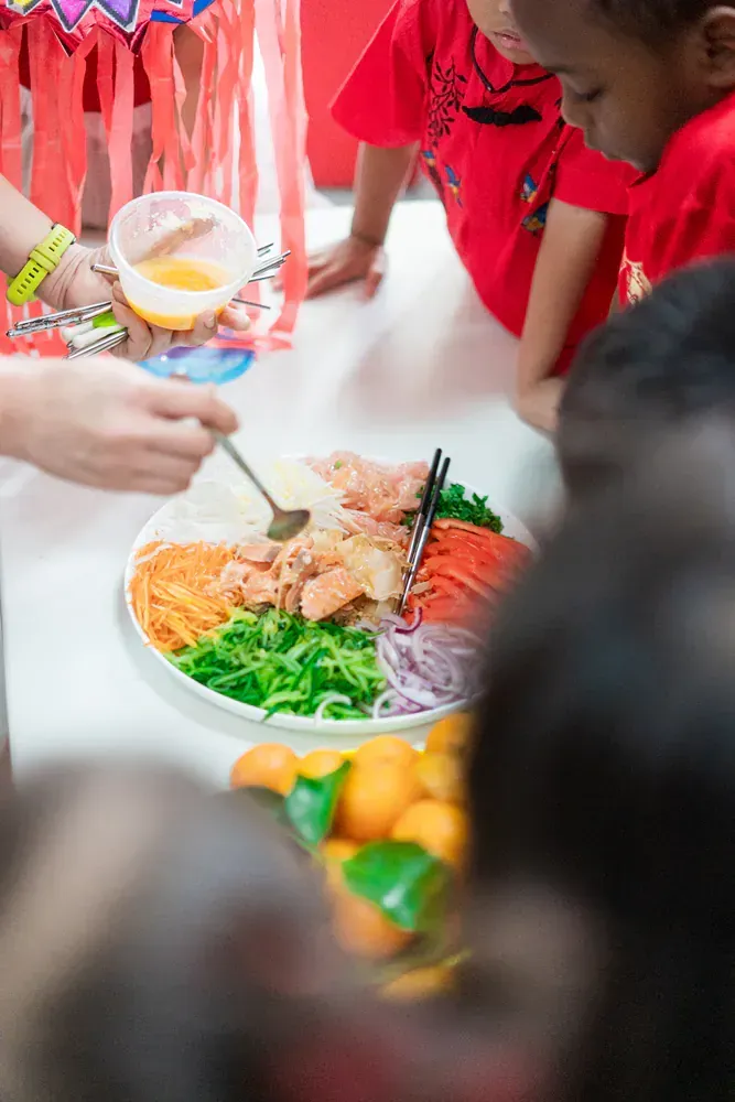 A group of children are sitting around a table eating food.