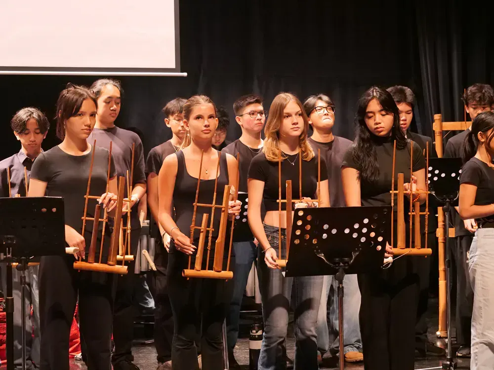 A group of young people are playing instruments on a stage.