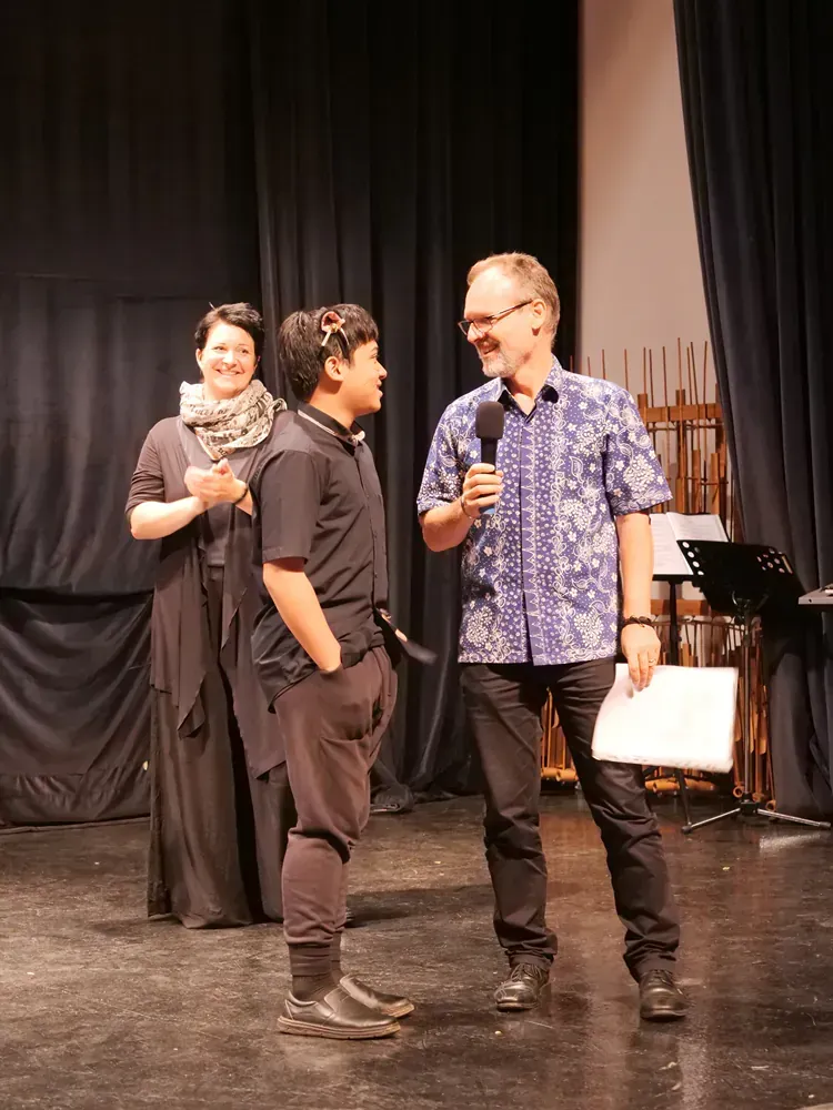 A group of people are standing on a stage talking to each other.