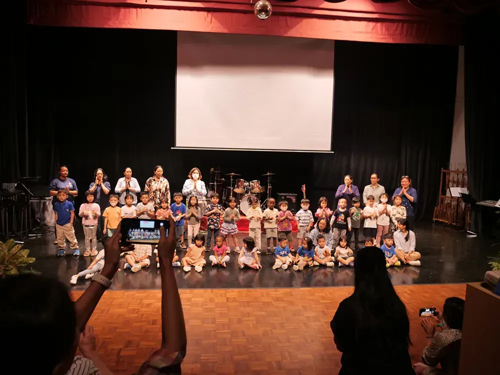 A group of children are posing for a picture on a stage.