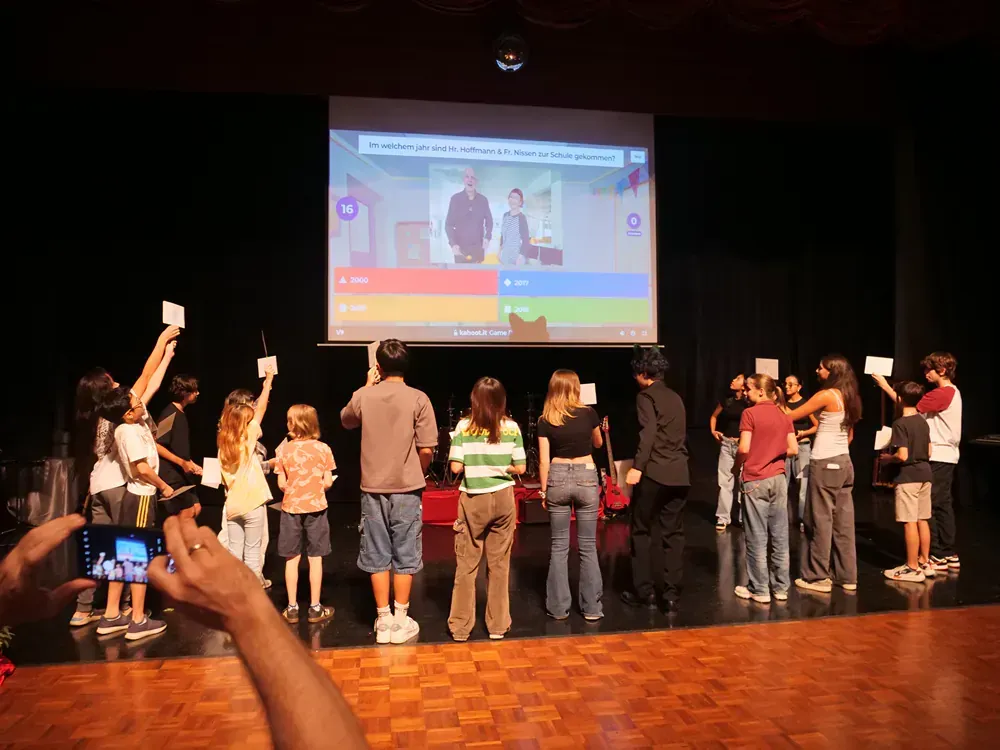 A group of people standing in front of a projector screen