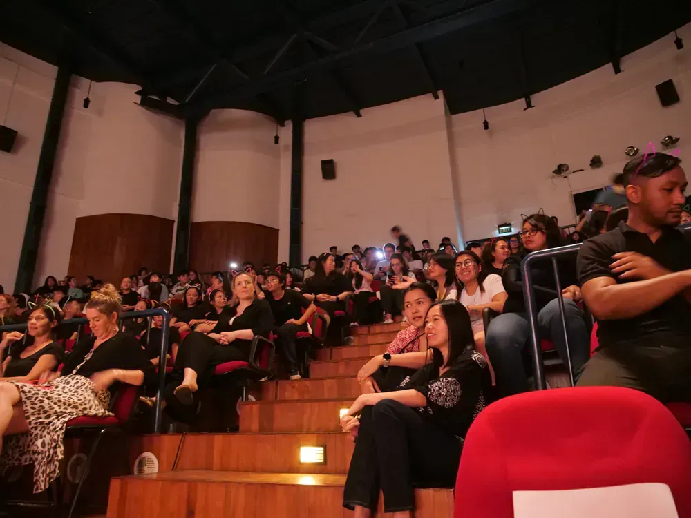 A large group of people are sitting in a large auditorium.