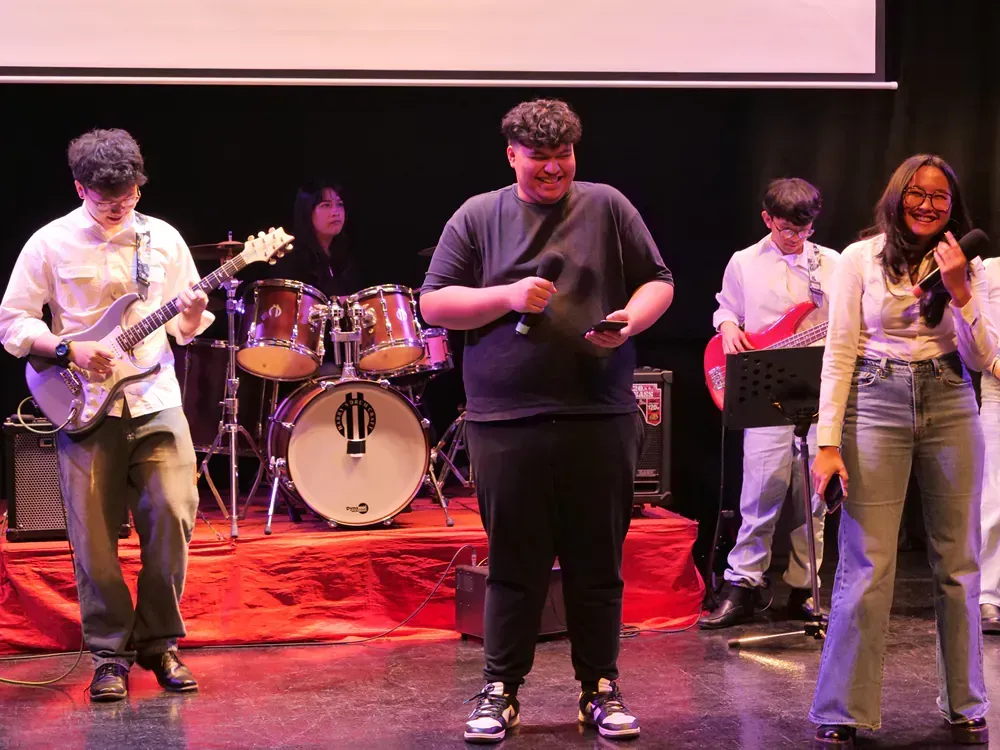 A group of people are standing on a stage playing instruments.