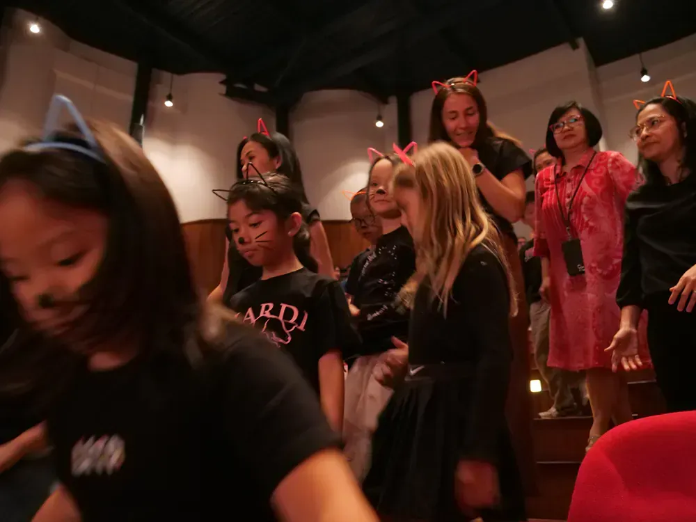 A group of young girls are dancing in a room.