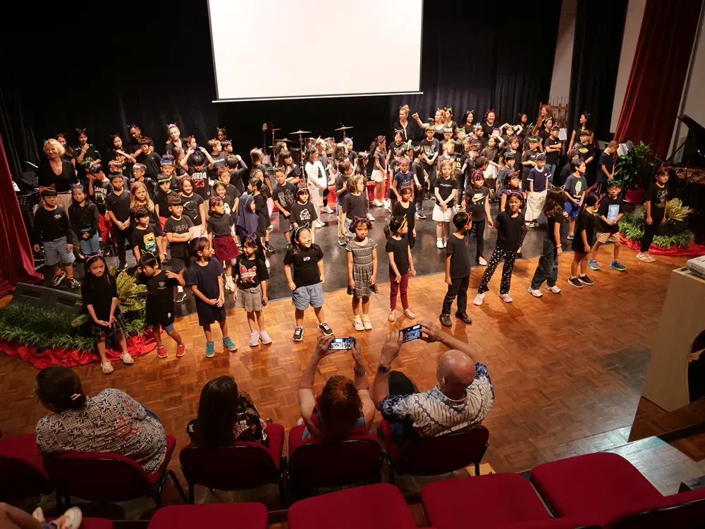 A large group of people are standing in a circle on a stage.