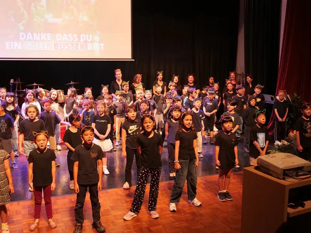 A large group of children are standing on a stage.