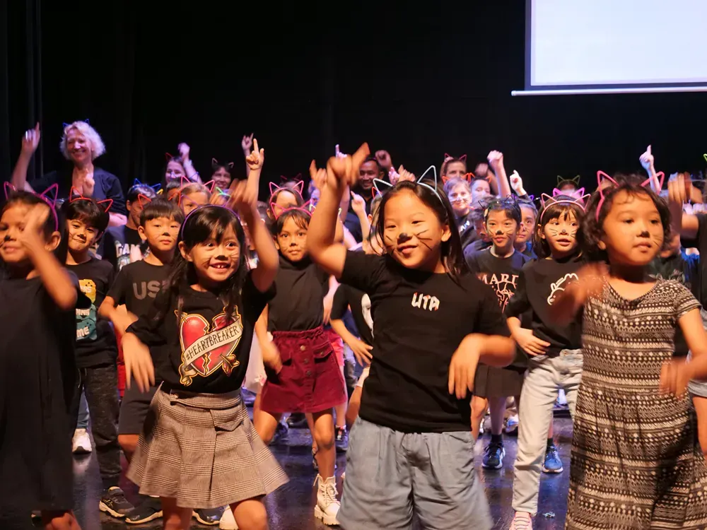 A group of children are dancing on a stage.