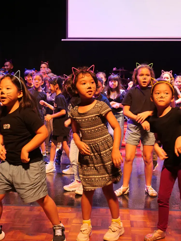 A group of young girls are dancing on a stage.