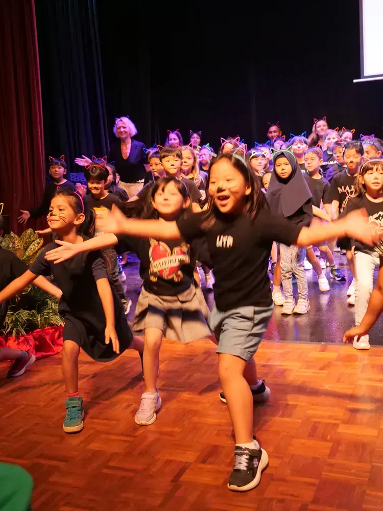 A group of children are dancing on a stage.