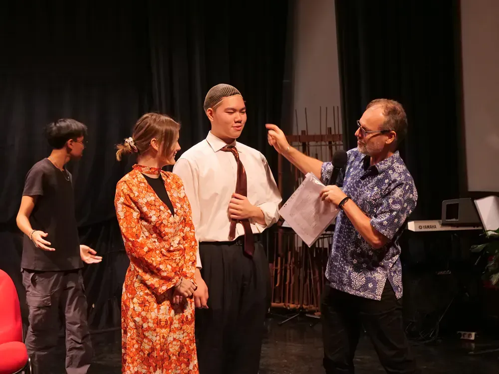 A group of people are standing on a stage talking to each other