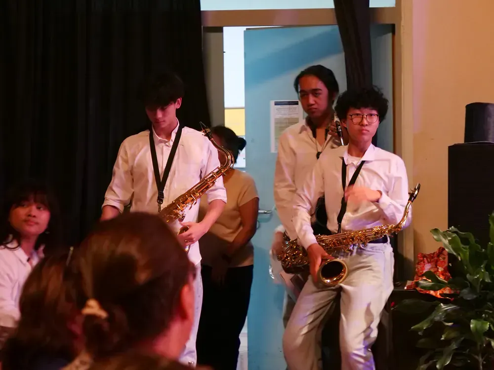 A group of people playing saxophones in a room