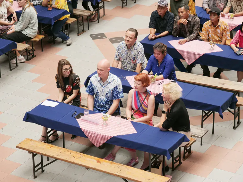 A group of people sitting at tables with blue tables cloths