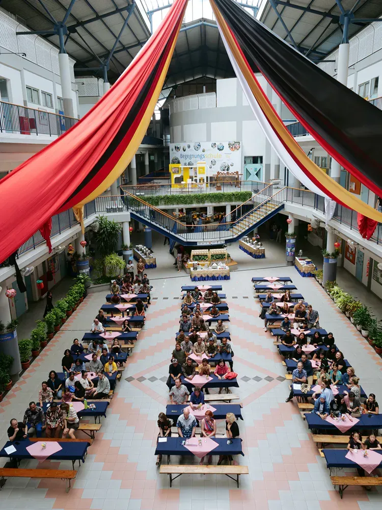 A large group of people are sitting at tables in a large building