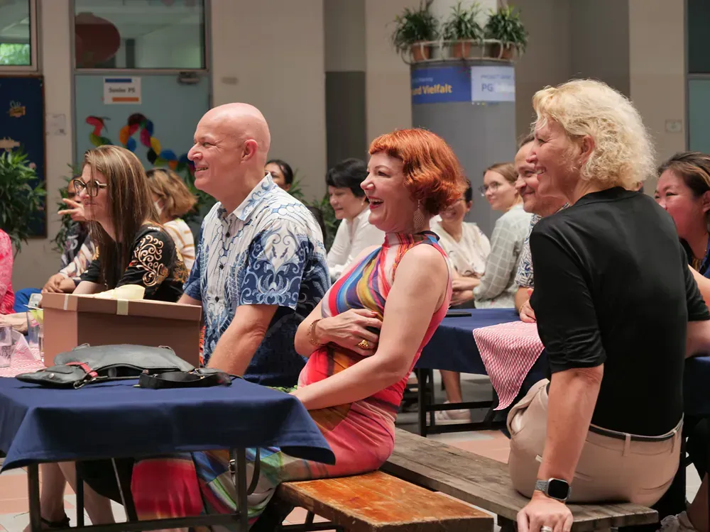 A group of people are sitting at tables laughing.