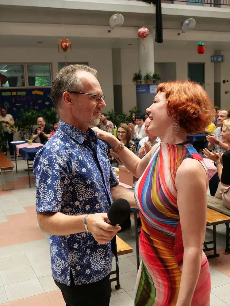 A man in a blue shirt is talking to a woman in a colorful dress