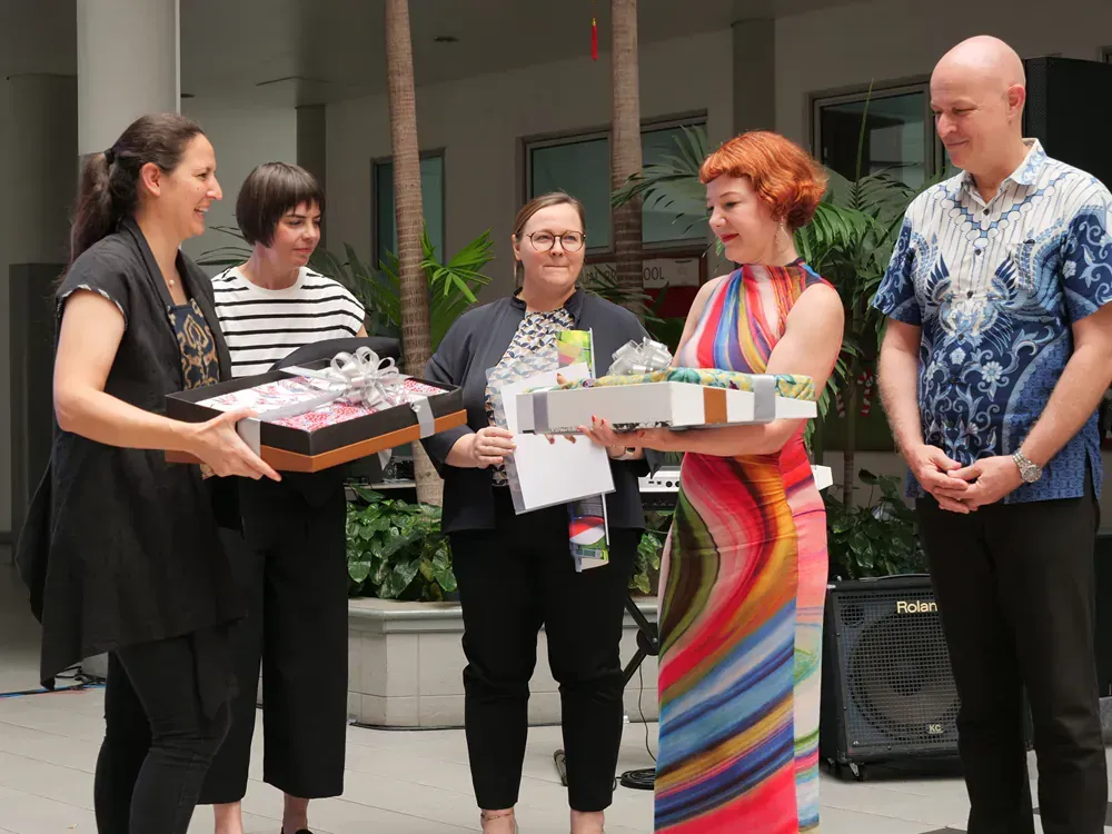 A group of people standing next to each other holding gifts