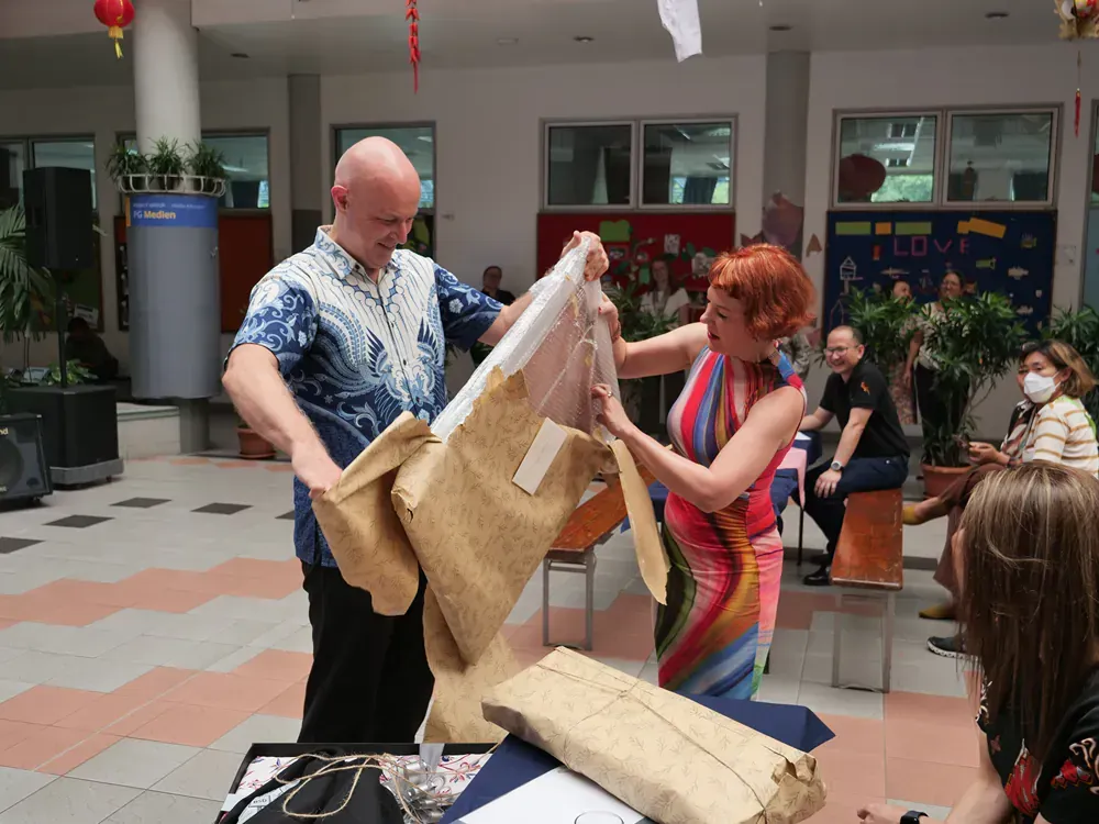 A man and a woman are holding a piece of fabric