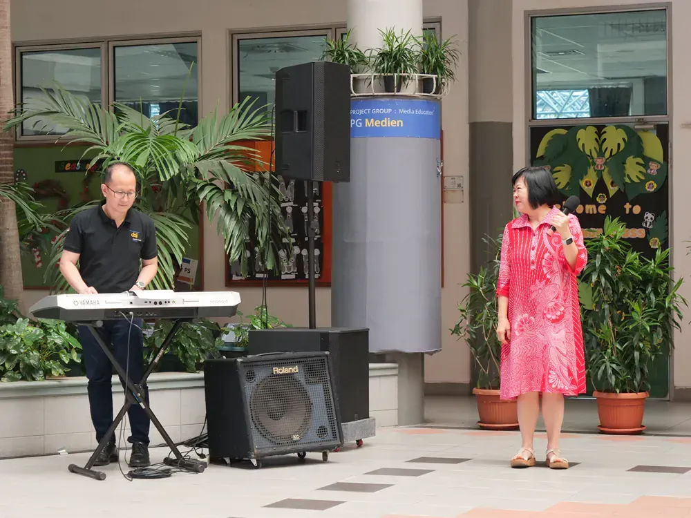 A man is playing a keyboard while a woman sings into a microphone.