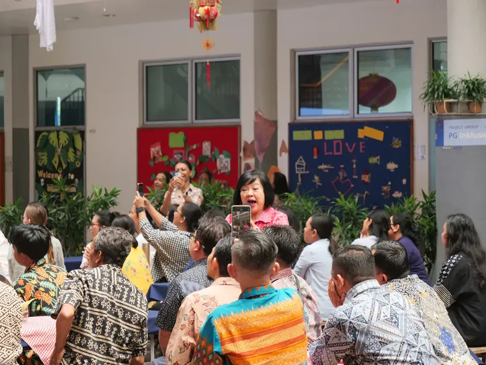 A group of people are sitting in front of a sign that says `` i love ''.