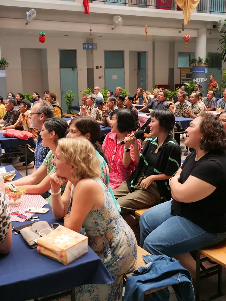 A group of people are sitting at tables in a large room