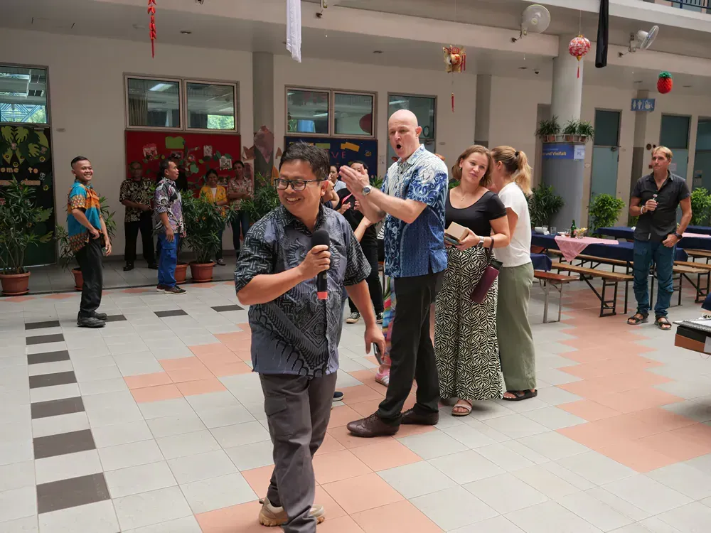 A group of people are standing around a man holding a microphone
