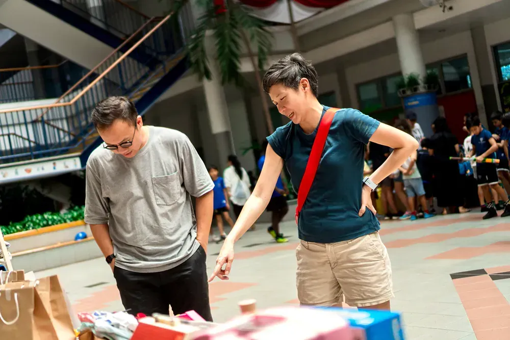 A man and a woman are looking at a table with boxes on it.