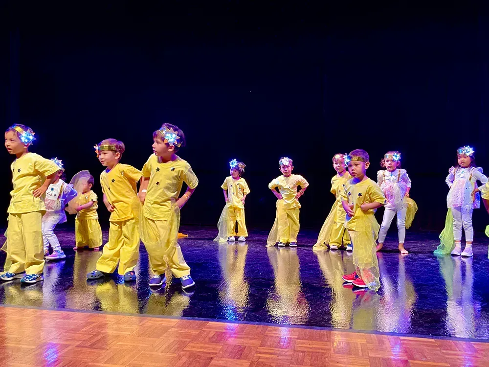 A group of children are dancing on a stage.