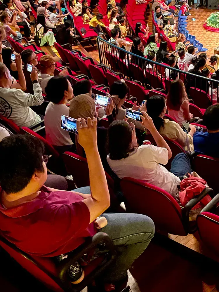 A group of people are sitting in a stadium watching a basketball game.