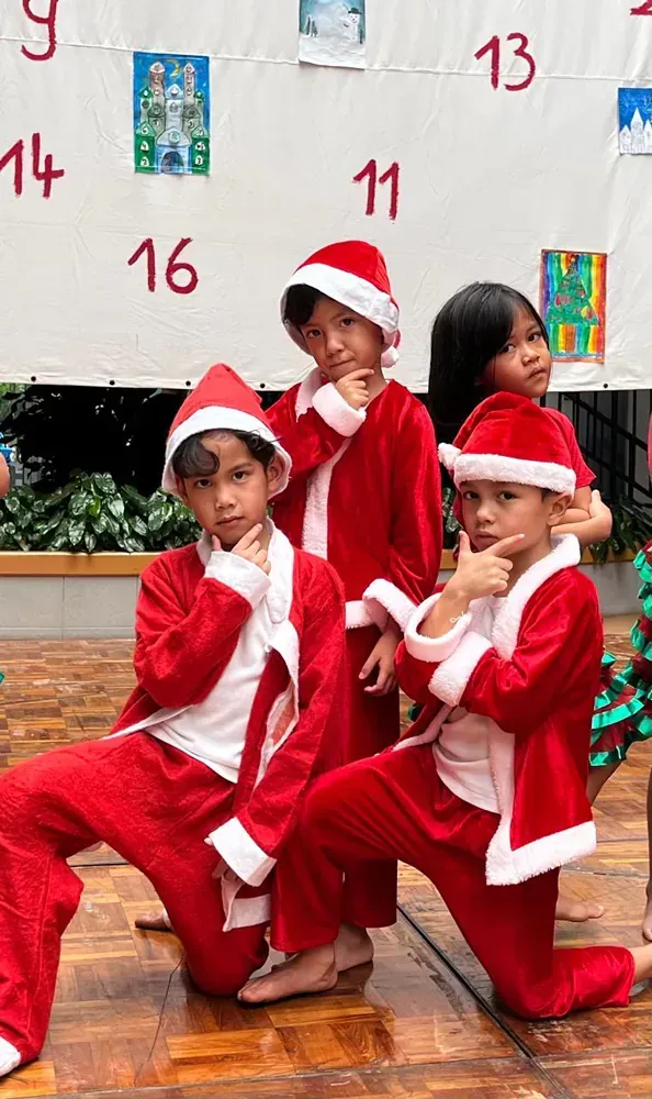 A group of children dressed in santa claus costumes are posing for a picture.