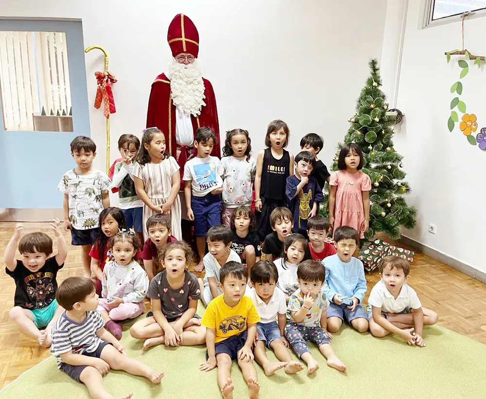 A group of children are posing for a picture with a man dressed as santa claus.