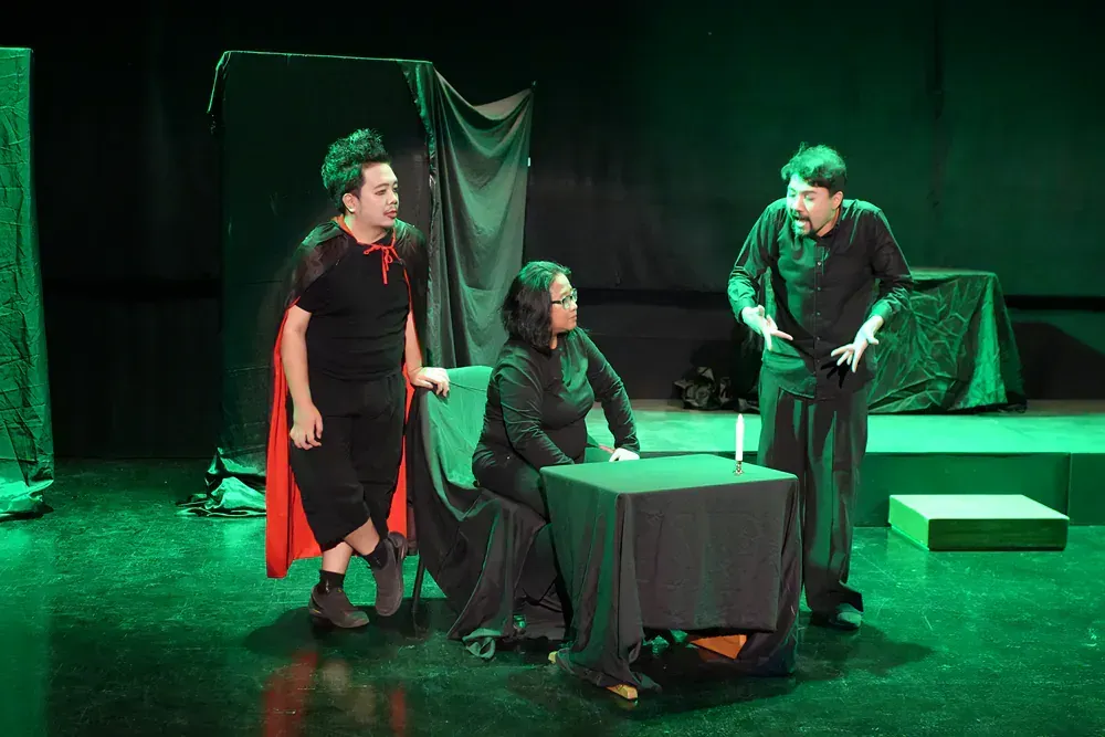 A group of people are standing around a table on a stage.