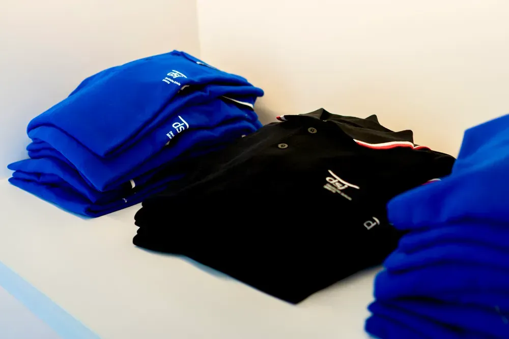 A stack of blue shirts and a stack of black shirts