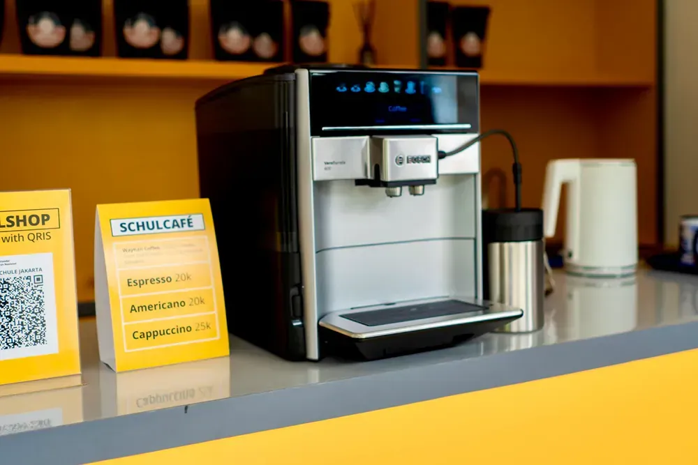 A coffee machine is sitting on a counter next to a sign.