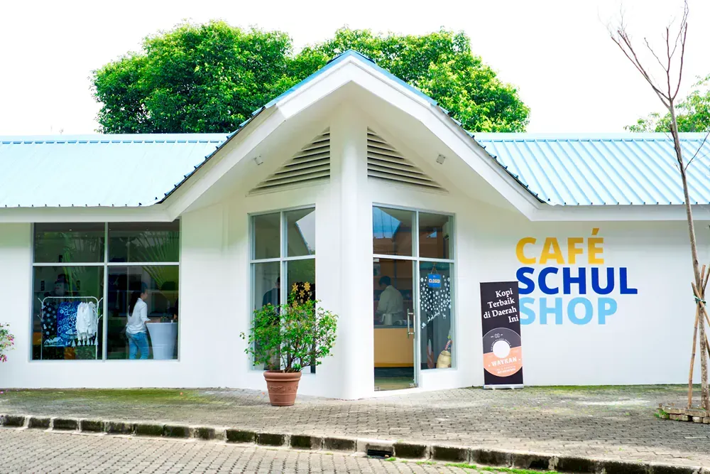 A white building with a sign that says cafe schul shop