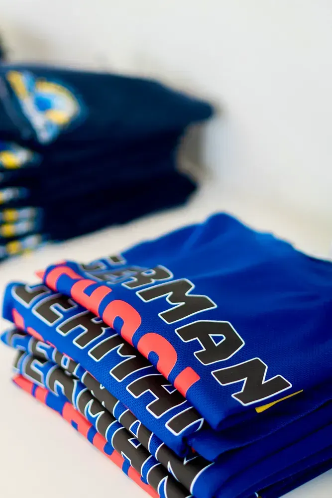A stack of blue shirts with the word team on them