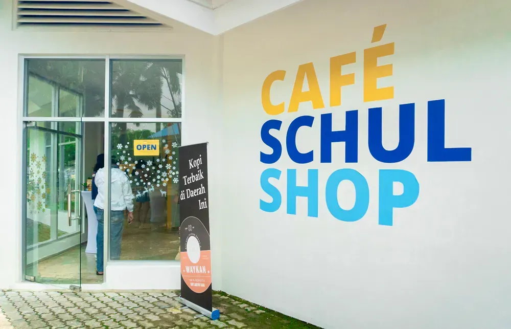 A white building with a sign that says cafe schul shop