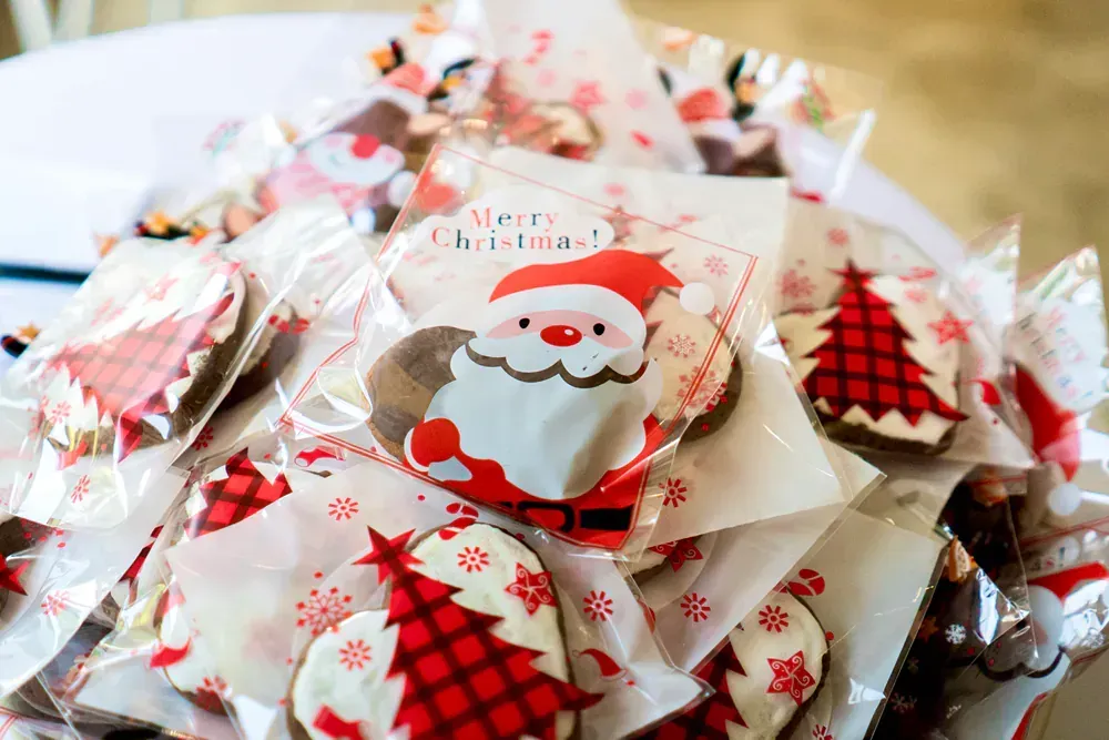 A pile of christmas cookies wrapped in plastic on a table.